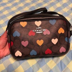 Brown & black crossbody coach purse with multicolored hearts